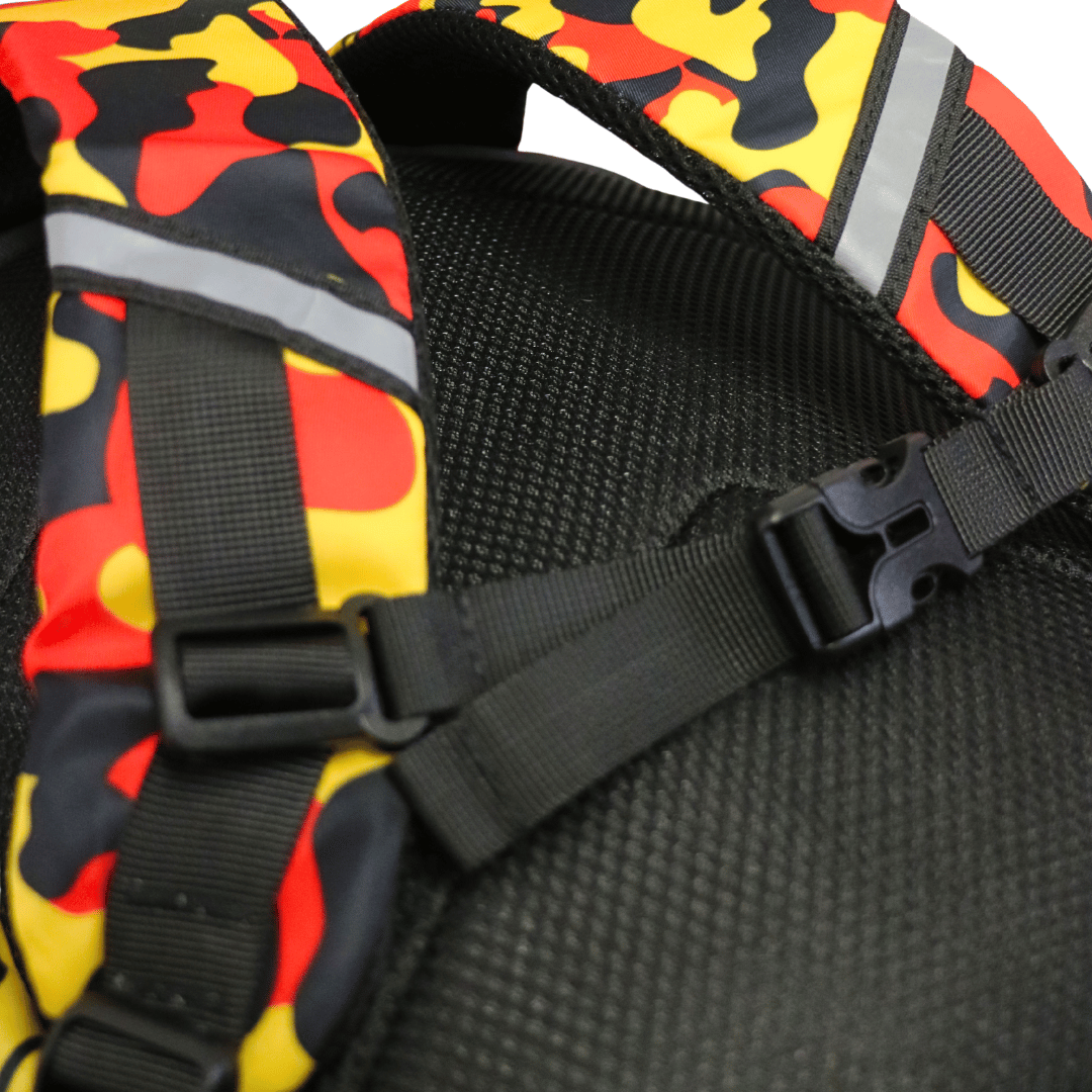 close-up of haus of ziggy lee everyday deadly backpack showing the black mesh back panel, black adjustable straps with buckles, and reflective gray strips over a red, yellow, and black camouflage pattern.