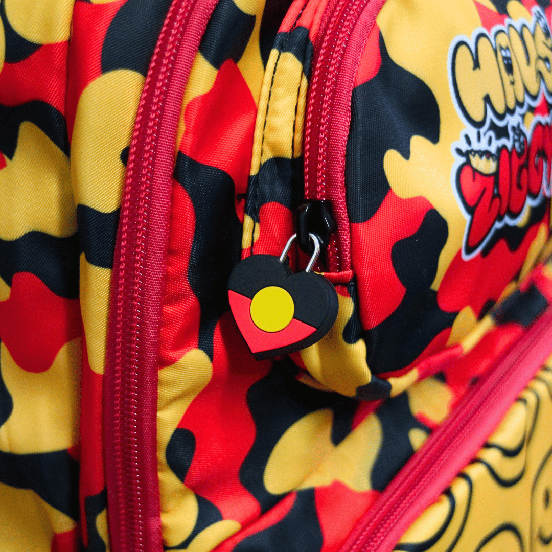 Close-up of haus of ziggy lee everyday deadly backpack with a red, yellow, and black camouflage pattern, red zippers, and a heart-shaped zipper pull featuring the aboriginal flag.