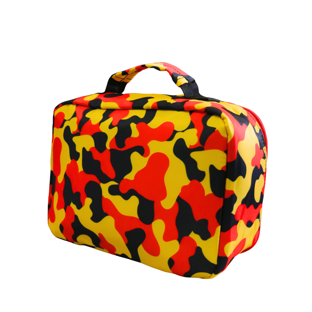 back view of haus of ziggy lee everyday deadly soft-sided lunch bag with a bold camouflage pattern in red, yellow, and black, featuring a top carry handle, shown on a plain white background.